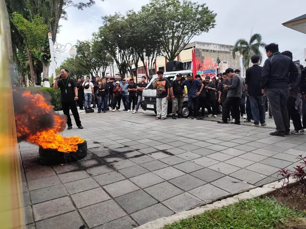 Massa Aliansi Balikpapan Melawan (Bakwan) membakar ban bekas saat aksi unjuk rasa di depan Kantor Wali Kota Balikpapan, Senin (9/2/2026), sebagai bentuk protes terhadap banjir dan layanan publik