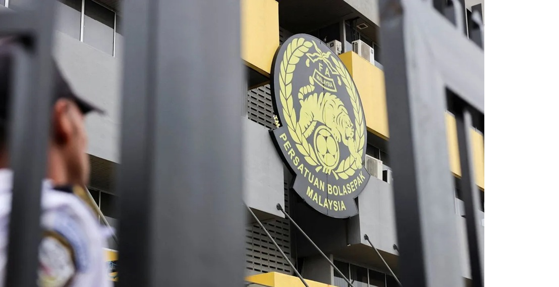 Petugas berjaga di dekat logo Asosiasi Sepak Bola Malaysia (FAM) di kantor pusat di Petaling Jaya, Malaysia