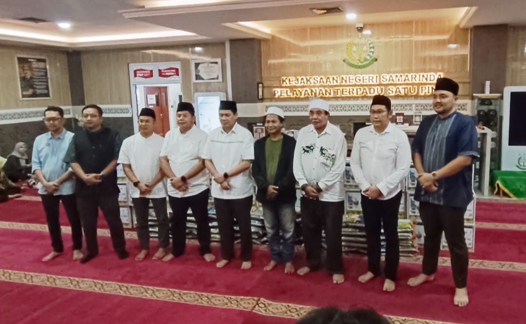 Kepala Kejaksaan Negeri Samarinda Haedar berdiri di tengah kenakan peci hitam dan kemeja putih foto bersama dengan para wartawan.