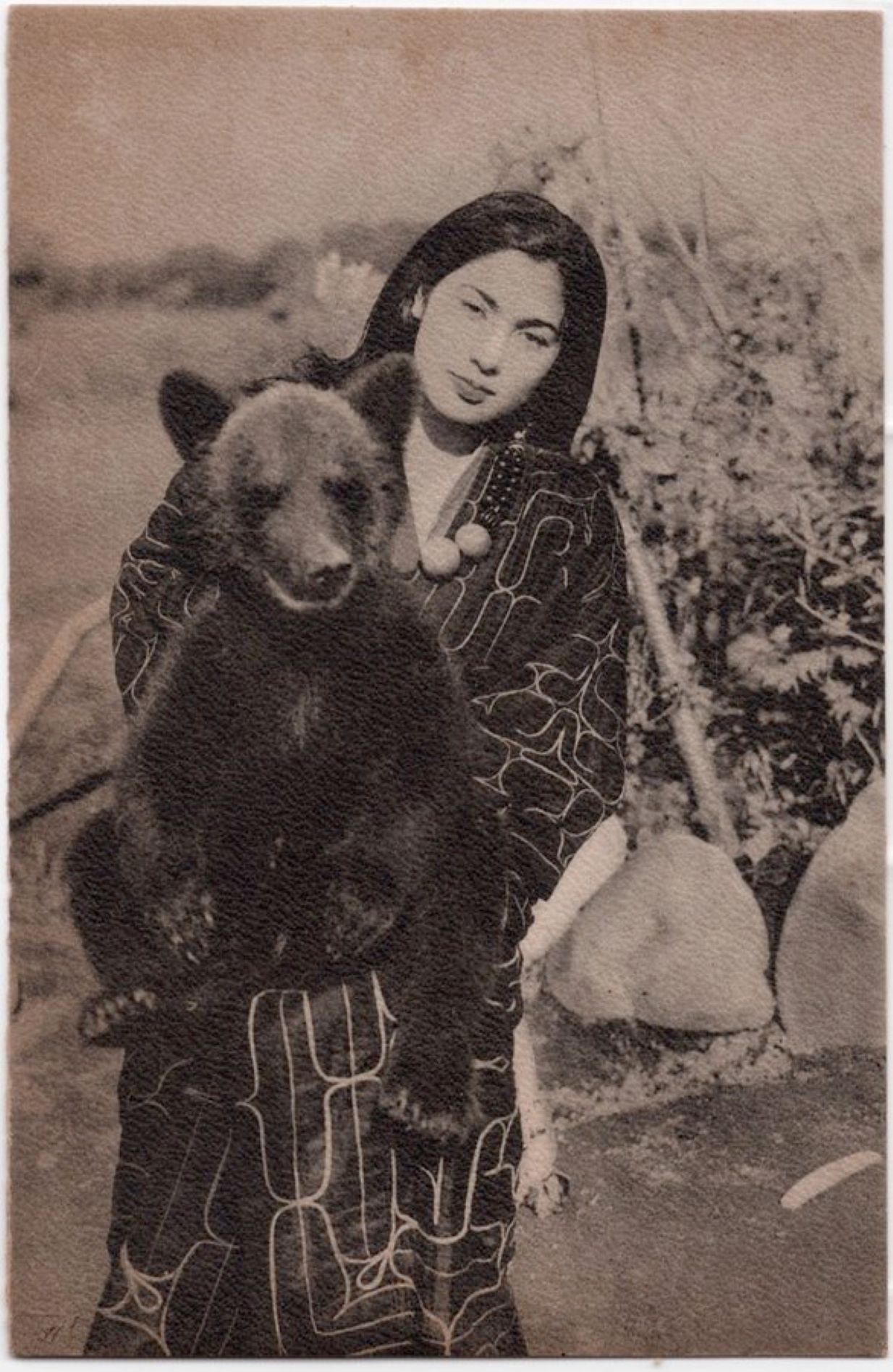 Wanita Ainu dengan anak beruang.