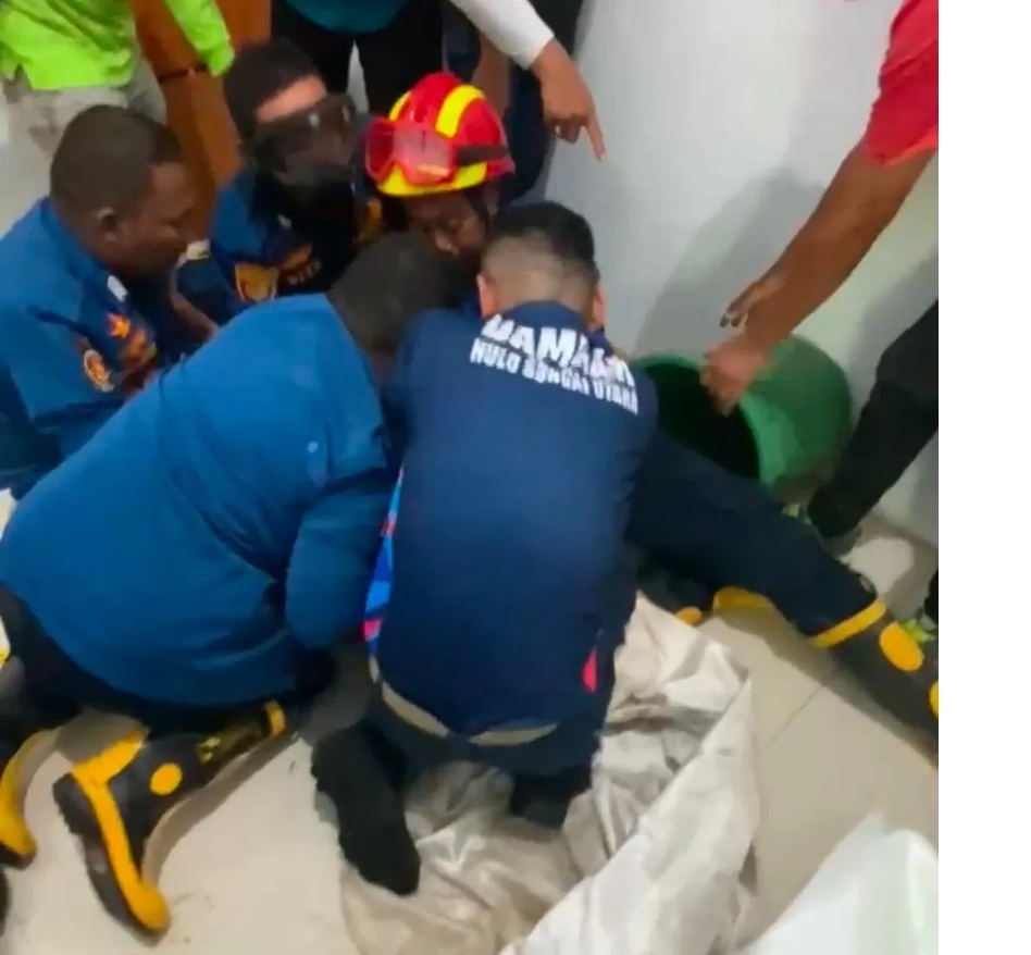 EVAKUASI: Petugas Damkar HSU berupaya mengevakuasi seekor beruk (bangkuy) yang terjebak di dalam toilet Kantor Diskuperindag HSU, Jumat (27/3/2026). (Foto: Istimewa) 