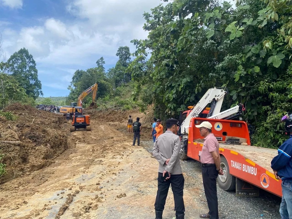 Alat berat membersihkan material longsor yang menutup jalur alternatif Batulicin&amp;ndash;Kandangan di kawasan Desa Emil Baru, Kecamatan Mantewe, Tanah Bumbu. (PKJR Tanah Bumbu) 