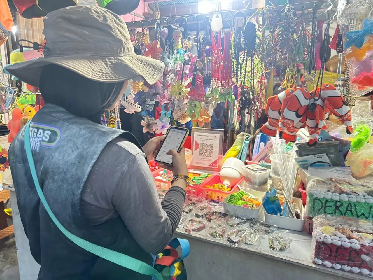 Sistem pembayaran QRIS kini semakin diminati karena mempermudah transaksi tanpa harus membawa uang tunai.