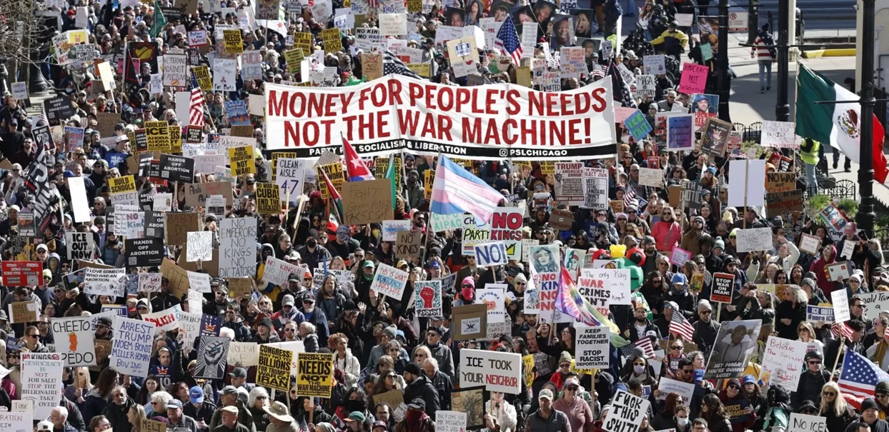 Jutaan orang membawa spanduk dan bendera saat mereka berbaris dalam aksi protes nasional  No King di Chicago.  