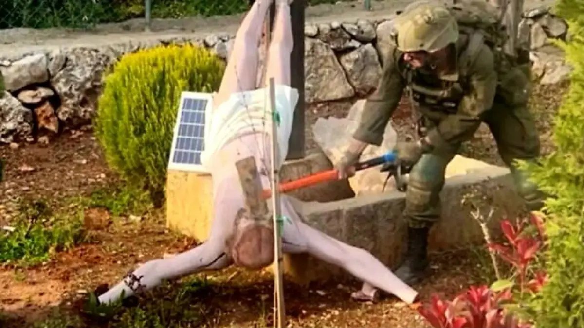 Seorang prajurit Israel Defense Forces (IDF) tampak menghancurkan patung Yesus Kristus di Lebanon selatan dalam gambar yang diunggah ke media sosial pada 19 April 2026 (The Times of Israel)