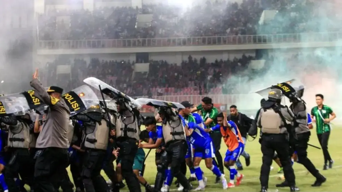 Aparat keamanan mengawal pemain Adhyaksa FC keluar lapangan Stadion Lukas Enembe, Jayapura, Jumat (8/5/2026), usai kericuhan pecah setelah Persipura Jayapura gagal promosi ke Super League musim depan. (ANTARA FOTO/GUSTI TANATI)