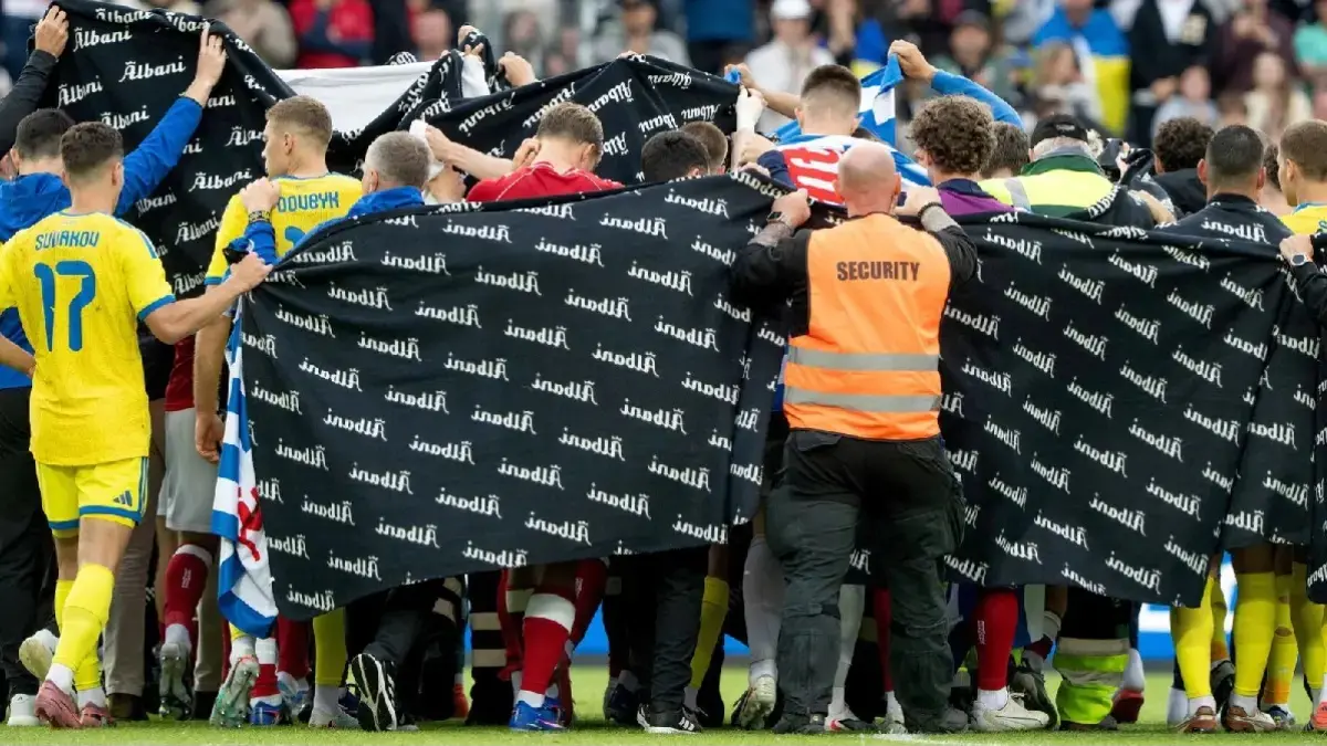 Para pemain dan staf Denmark dan Ukraina membentuk lingkaran di sekitar Eriksen saat ia menerima perawatan. (SkySports)