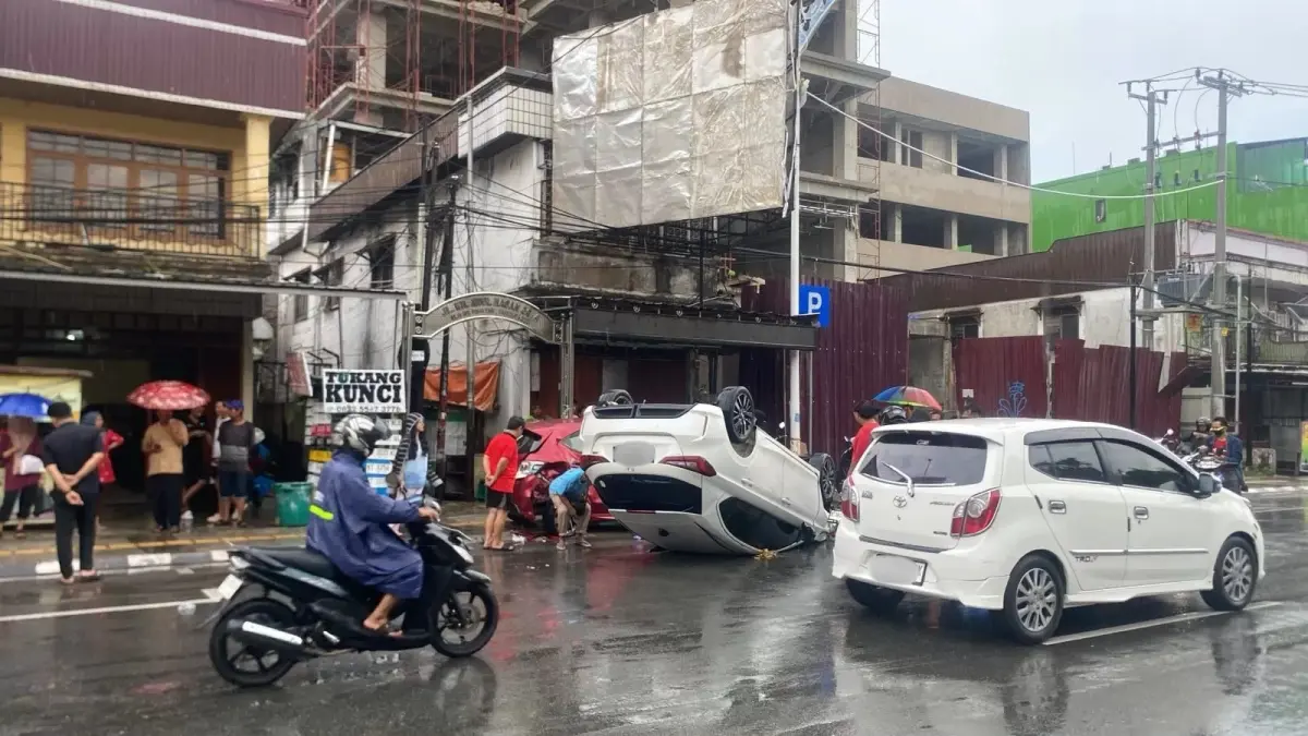 Sebuah mobil Honda City terguling setelah menabrak mobil yang sedang terparkir di Jalan Abul Hasan, Kecamatan Samarinda Kota, Minggu (28/6/2026) sore. (kis)