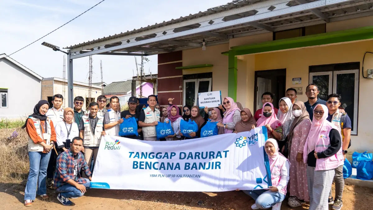 Manajemen PLN UIP3B Kalimantan bersama YBM PLN, PLN UP2B Kalselteng, Srikandi PLN, dan warga berfoto bersama usai menyerahkan 60 paket sembako kepada 60 kepala keluarga terdampak banjir di Perumahan Berkat Sekumpul Indah.