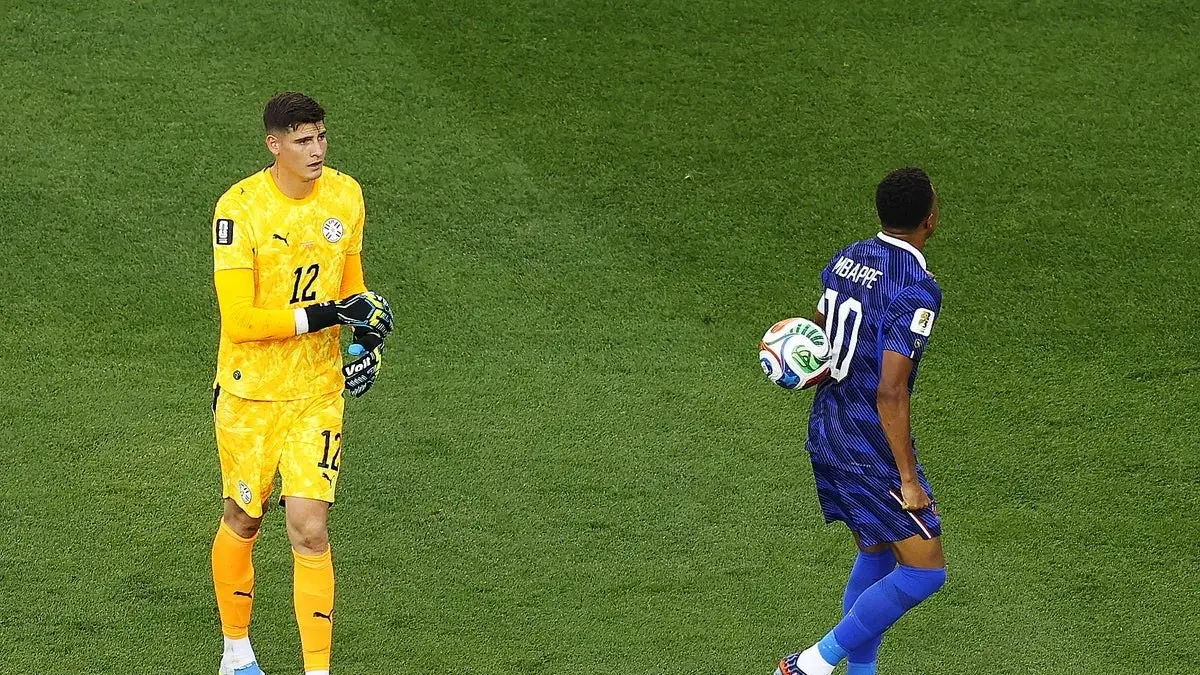 Penjaga gawang Paraguay, Orlando Gills melempar bola ke badan Mbappe.