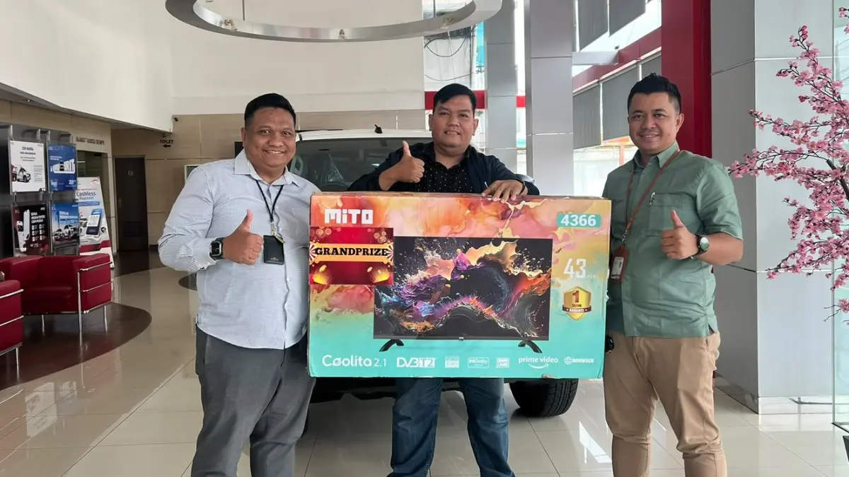 Martono Cahyadi (kiri) dan Nur Kholis dari Auto2000 MT Haryono menyerahkan hadiah utama Android TV kepada Wawan, peserta test drive Toyota New Hilux yang beruntung.