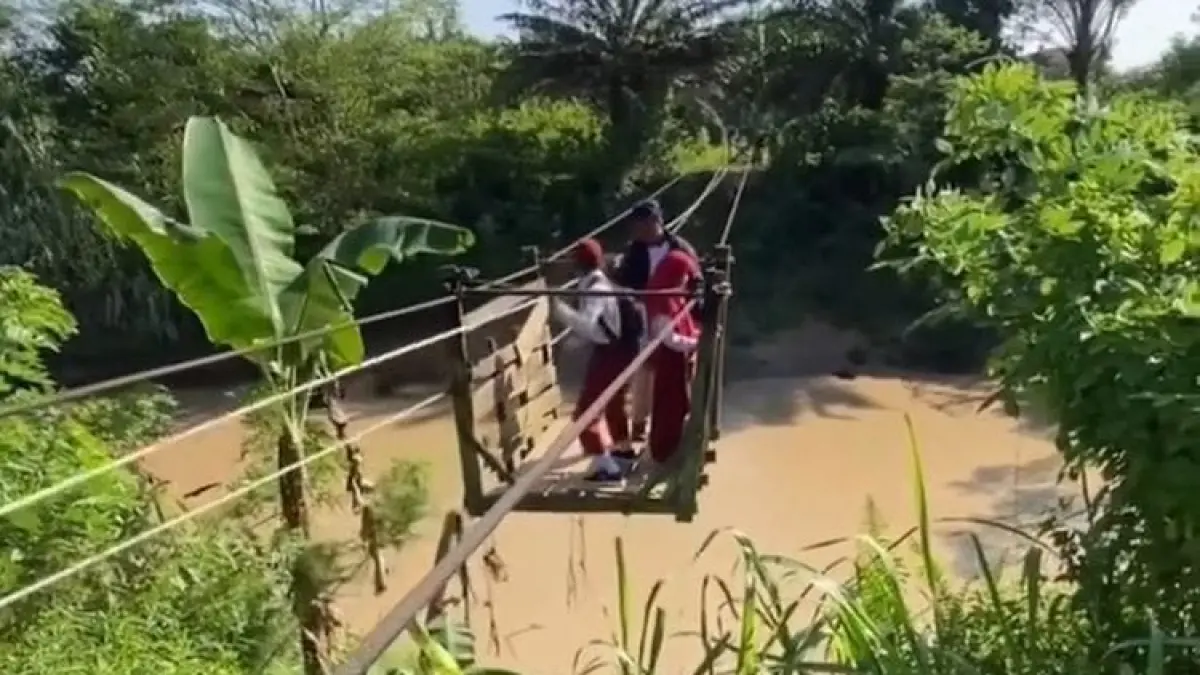 Tangkapan layar anak sekolah menyeberangi sungai di Desa Santan Ulu, Muara Badak (Istimewa)