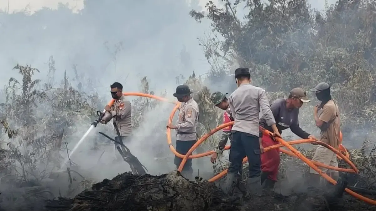KARHUTLA: Polres Sambas bersama tim saat melakukan pemadaman kebakaran lahan. (ISTIMEWA)