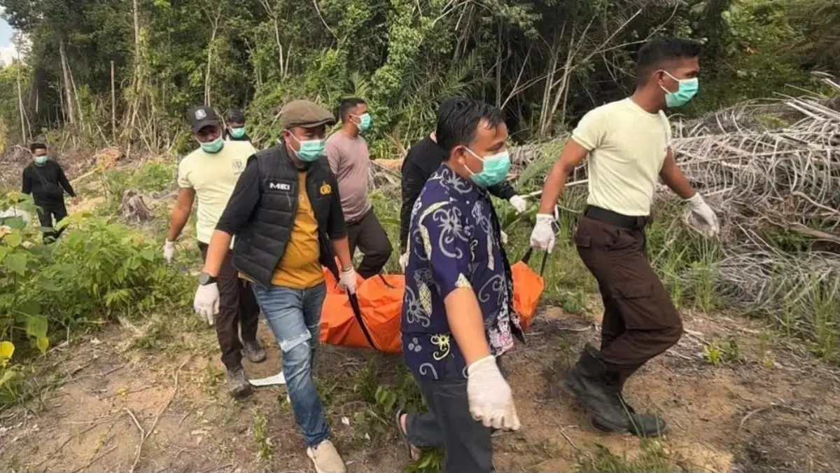 Polisi mengevakuasi jasad korban pembunuhan yang dikubur di areal perkebunan kelapa sawit di Kecamatan Manis Mata, Jumat (24/7). (ISTIMEWA)
