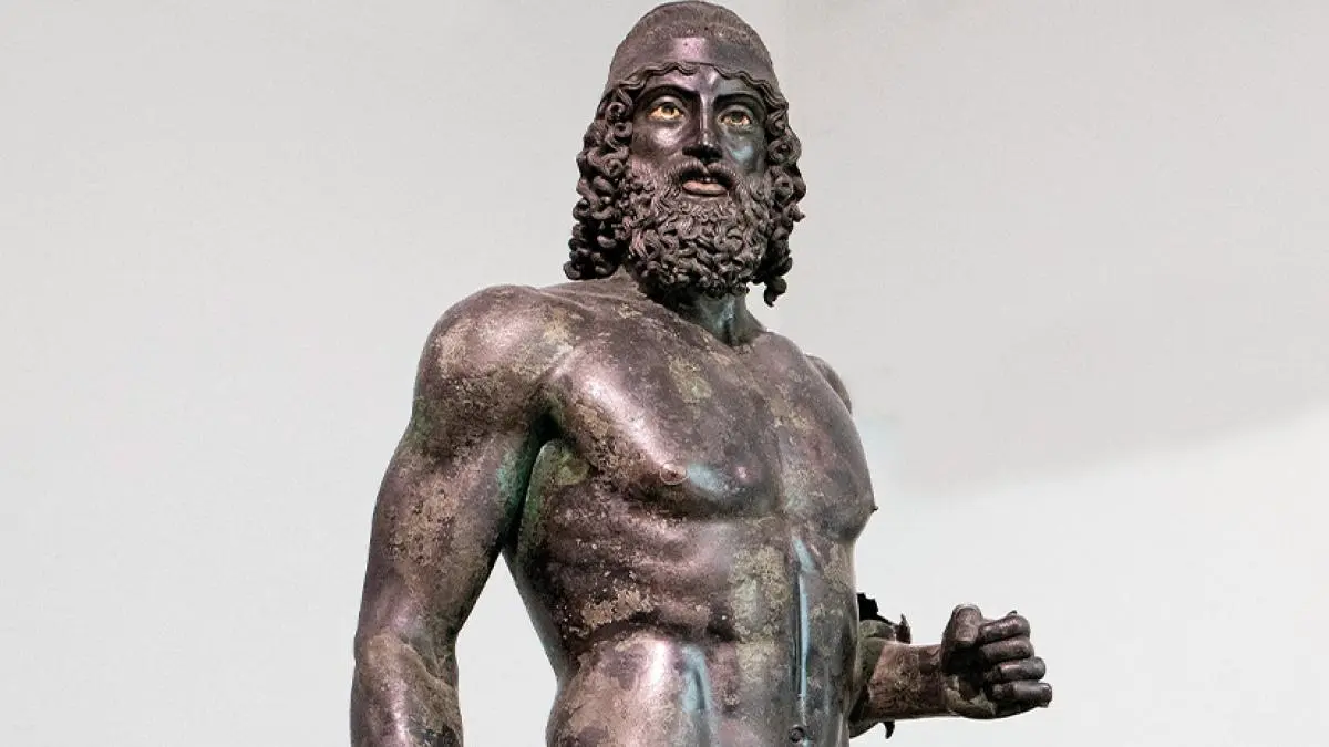 Prajurit perunggu tersebut berdiri megah di dalam ruangan beriklim khusus di atas fondasi marmer Carrara antisismik di Museo Nazionale della Magna Grecia, Reggio Calabria.