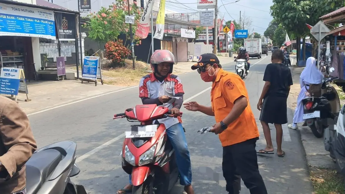 BPBD Kukar membagikan masker gratis untuk pengendara di Tenggarong dalam rangka mencegah ISPA (Ist/BPBD Kukar)