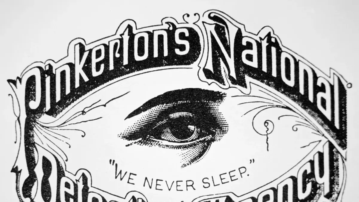 Logo Pinkerton berwujud mata terbuka lebar dengan tulisan "We Never Sleep".