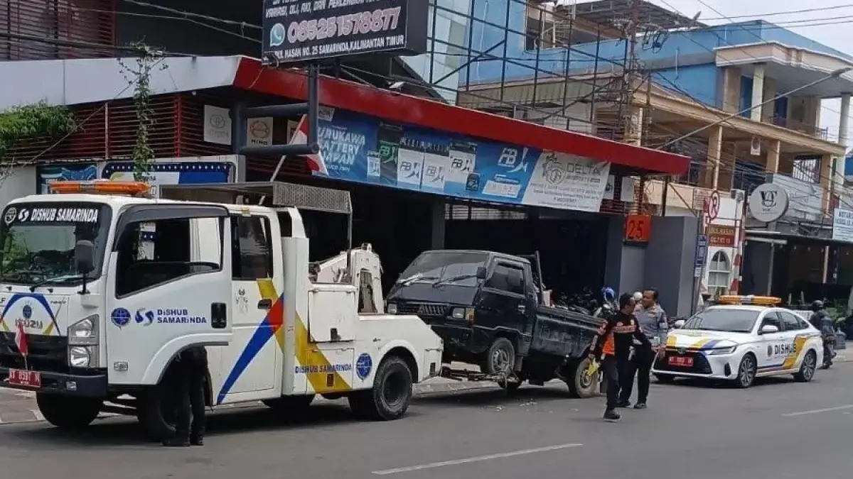 Petugas saat menderek mobil yang melanggar aturan di Jalan Abul Hasan. ​
