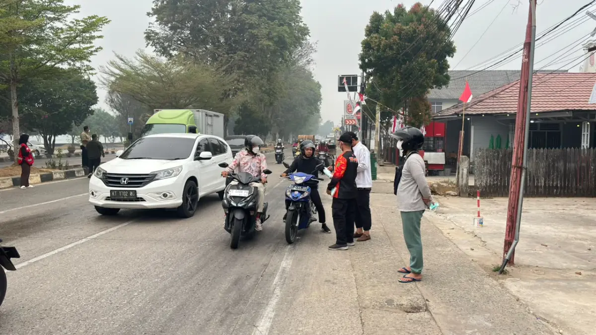 Pembagian masker gratis oleh BPBD Kukar di Simpang Tiga Kumala (Elmo/Prokal.co)