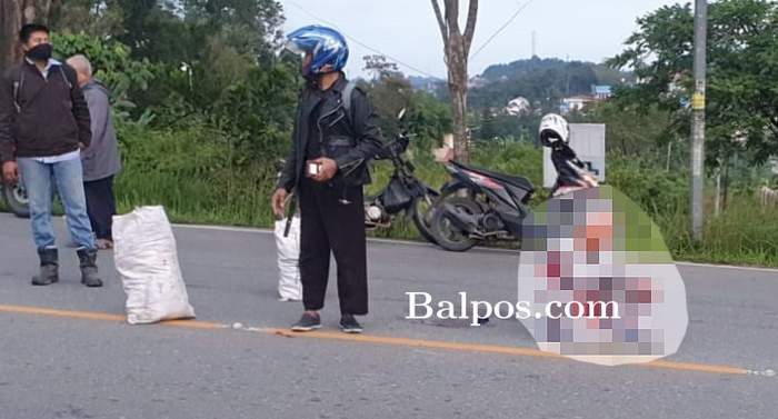 TERDUDUK: Korban dalam kondisi berdarah-darah masih mampu duduk setelah mengalami kecelakaan