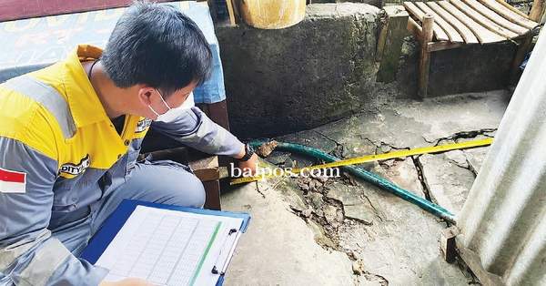 DATA KERUSAKAN: Petugas RDMP JO melakukan pengecekan terhadap rumah warga yang terdampak proyek.