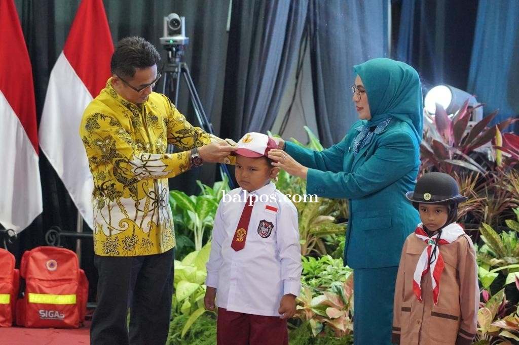 SERAGAM GRATIS: Wali Kota dan Ketua TP PK saat memakaikan seragam SD secara simbolis pada acara HKG ke-51 TP PKK Balikpapan di BSCC Dome, . (IST)