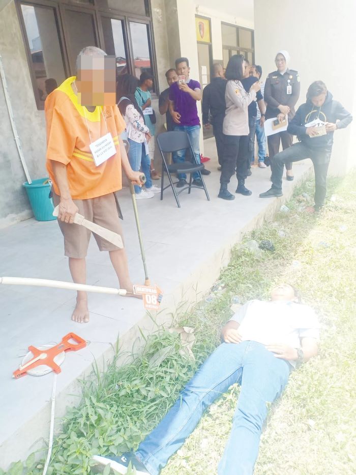 MASALAH TANAH: HS saat memperagakan aksinya menimpas korban yang tak lain masih keluarganya sendiri.
