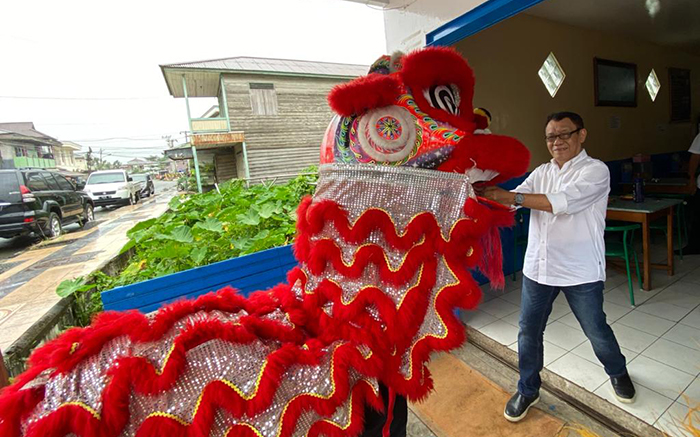 ANGPAU: Penulis ketika memberikan angpau pada ‘singa’ atau lion yang berkeliling Kota Tanjung Redeb.