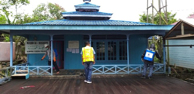 PENCEGAHAN: Petugas PT IPB saat  melakukan penyemprotan disinfektan di beberapa fasilitas di Kampung Tanjung Perangat, kemarin (29/3).