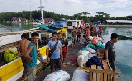 BONGKAR MUAT: Para anak buah kapal atau ABK saat melakukan proses bongkar muat barang sembako di dermaga Teluk Sulaiman, Kecamatan Bidukbiduk.