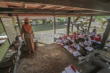MANFAATKAN KOLONG RUMAH: Karena jaringan internet tidak mendukung, murid-murid SDN 002 Maluang di Paribau, Kecamatan Gunung Tabur, terpaksa belajar tatap muka memanfaatkan kolong rumah milik warga setempat. Foto  diabadikan Selasa (21/7) lalu.
