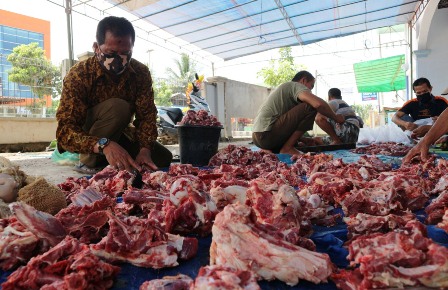 PATUHI PROTOKOL KESEHATAN: Panitia saat mempersiapkan potongan hewan kurban yang akan dibagikan kepada masyarakat kemarin (31/7).
