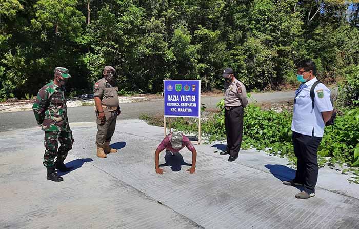PERINGATAN: Masyarakat yang tidak menggunakan masker saat di luar rumah, dihukum push-up oleh tim saat Razia Yustisi Protokol Kesehatan di Kecamatan Maratua kemarin (22/9).