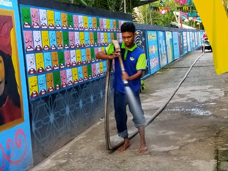 AKSI SOSIAL: Anggota tim GRT Kelurahan Gayam saat melakukan penyemprotan jalan.