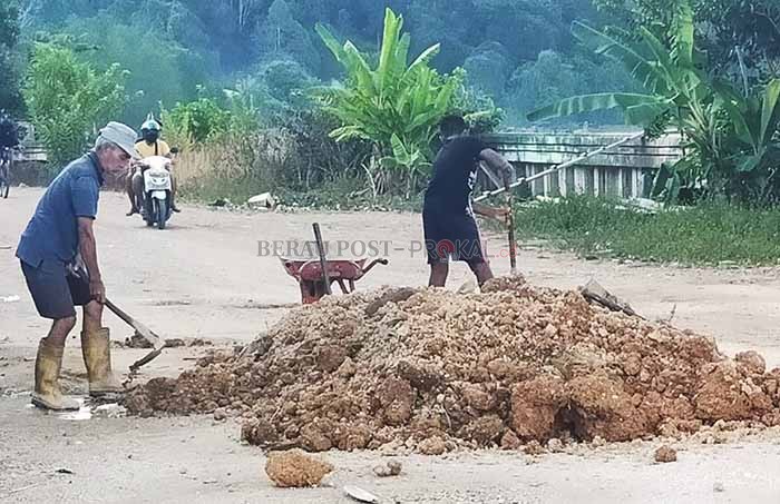 GOTONG-ROYONG: Warga RT 1 Kelurahan Gunung Tabur cukup antusiasi saat gotong-royong menambal lubang di Jalan Kuran, (7/11).