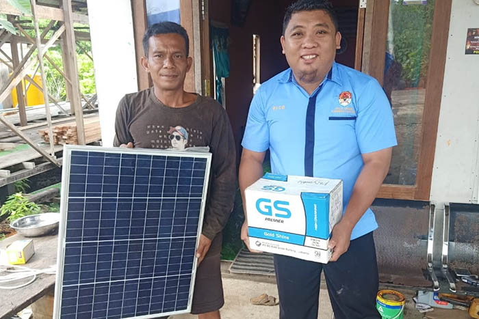 PENUHI KEBUTUHAN LISTRIK: Kasi Pelayanan Kantor Kampung Payung-Payung, Rico, menyerahkan panel surya kepada masyarakat. Program ini untuk memenuhi kebutuhan listrik masyarakat.