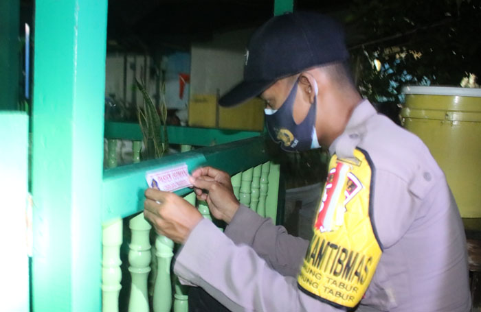 TEMPEL STIKER: Satgas Kelurahan Gunung Tabur saat menempel stiker di rumah warga yang menjalani isolasi mandiri Minggu (28/2) malam.