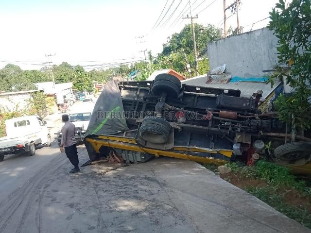 LAKA TUNGGAL: Polisi mengatur lalu lintas untuk mencegah kemacetan di lokasi truk yang terseret karena tak mampu menanjak.