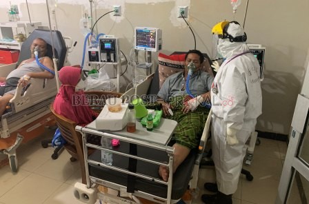 PERJUANGAN DOKTER DAN PASIEN: Seorang dokter melakukan pemeriksaan terhadap pasien Covid-19 di ruang ICU RSUD dr Abdul Rivai, kemarin (14/7). Dokter harus selalu melakukan pemeriksaan untuk memastikan kondisi pasien.