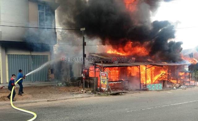 KEBAKARAN: Petugas pemadam kebakaran dari BPBD Berau berjibaku memadamkan kobaran api yang menghanguskan tiga tempat usaha, kemarin (5/8).
