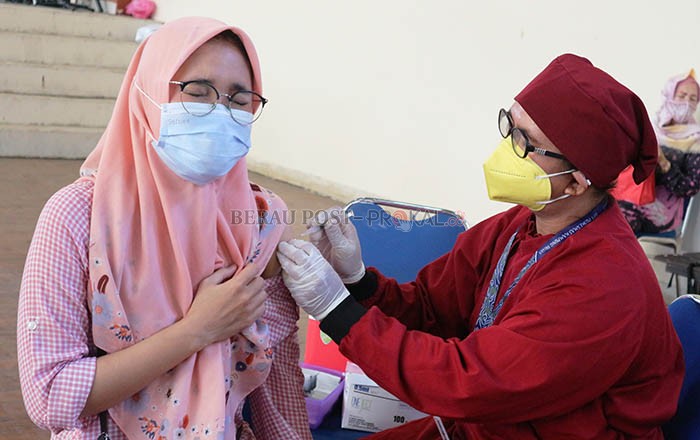 VAKSINASI MASSAL: Salah seorang warga menerima suntikan vaksin pada kegiatan vaksinasi massal di GOR Graha Pemuda, kemarin (25/8) . Tampak masyarakat mengantre untuk mendapatkan vaksin.