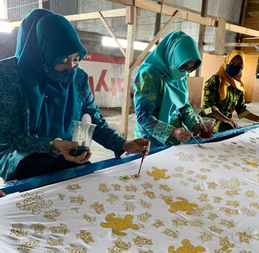 MEMBATIK: Ketua TPP PKK Kaltim Nobaiti Isran Noor sempat menyoba membantik di rumah produksi batik di Kampung Maluang.