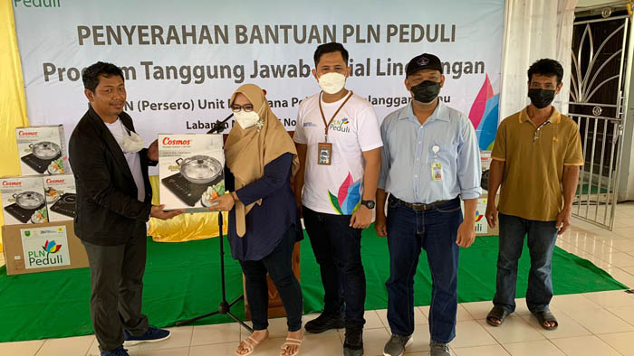 SERAHKAN BANTUAN: Manajer UP3 Berau, Deni Setiawan, menyerahkan bantuan kompor induksi kepada Kepala Kampung Labanan Makmur, Mupit Datusahlan, kemarin (5/11).