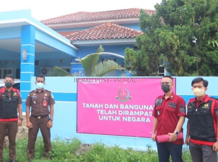 DIRAMPAS NEGARA: Tim kejaksaan memasang spanduk perampasan tanah dan bangunan milik terpidana kasus tipikor pembebasan lahan lapangan sepak bola tahun anggaran 2014, kemarin (10/5).