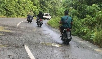 BERLUBANG: Jalan di Kampung Payung-Payung sudah banyak yang berlubang.