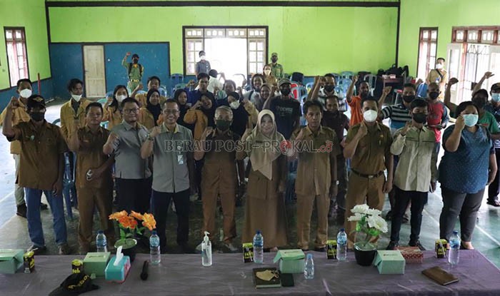 FOTO BERSAMA: Kepala BPJS Ketenagakerjaan Kantor Cabang Berau Sonny Alonsye dan Kepala DPMK Berau Tentram Rahayu, foto bersama sejumlah perwakilan kecamatan dan kampung, juga masyarakat penerima kartu BPJS Ketenagakerjaan.