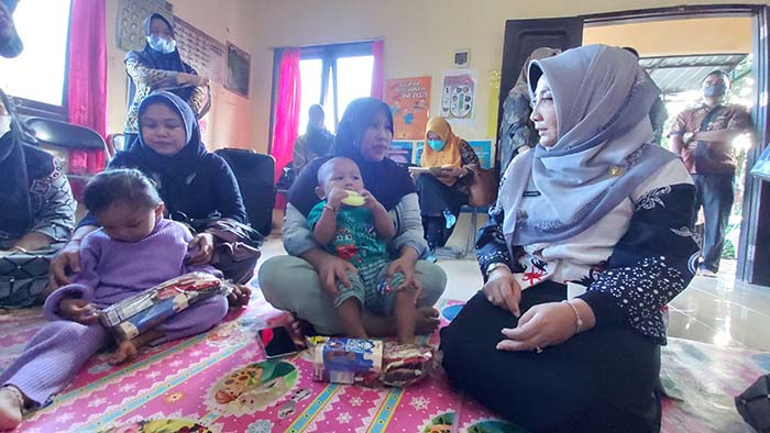 DEKAT DENGAN RAKYAT: Bupati Berau Sri Juniarsih saat berbincang dengan salah satu warga setempat yang sedang mengantarkan anaknya di Posyandu Mayang Merah.