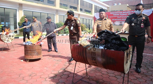 DILINDAS ALAT BERAT: Wakil Bupati Gamalis dan Ketua DPRD Madri Pani, bersama Forkopimda, melakukan pemusnahan barang bukti dari 155 perkara yang sudah inkrah, di halaman Kejaksaan Negeri Berau kemarin (27/9).