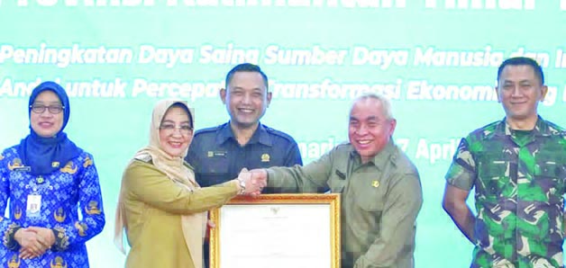 BUAH KERJA BERSAMA: Bupati Berau Sri Juniarsih menerima langsung penghargaan yang diserahkan oleh Gubernur Kaltim, Isran Noor, kemarin.