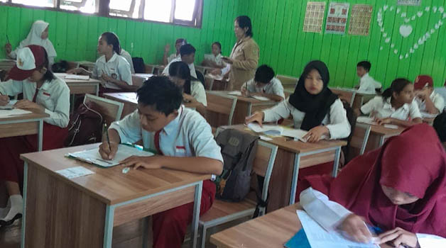 TETAP ANTUSIAS: Sejumlah peserta didik tetap antusias hadir untuk melaksanakan ujian, meski harus menembus banjir dari rumah menuju sekolah.